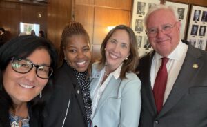 A group of four poses for a selfie in the Oregon Governor's Ceremonial Office.